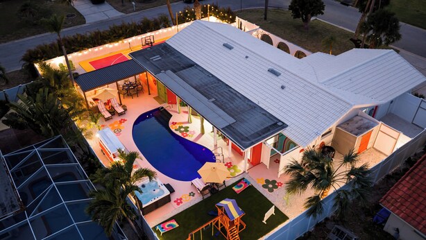 A residential property with a swimming pool, patio, and a covered outdoor seating area. - Hippie House-5 bedroom, Sleeps 12! Pool, Basketball, Mini golf, Pickleball Ct! (Bradenton)
