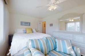 A bedroom with a bed, a ceiling fan, a dresser, a mirror, and a sign that says 'Beach'. - Bayberry Woods condo with fast WiFi, on-site pool, tennis & pickleball (Bethany Beach)