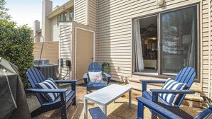 An outdoor patio with Adirondack chairs, a table, and a grill. - Sea Pines Village Beach House with Fast WiFi, Full Kitchen, A/C, & a Shared Pool (Bethany Beach)