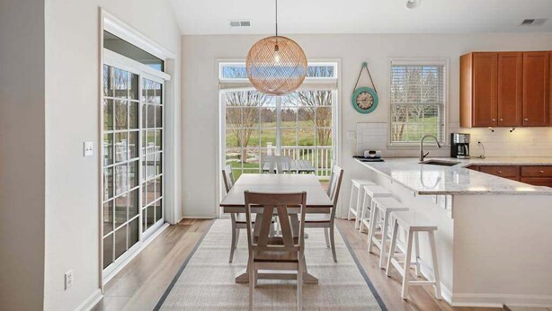 A modern kitchen with a large island, white cabinetry, and a view of the outdoors. - Bear Trap Dunes townhome with central AC & washer/dryer - on-site pools & tennis (Ocean View)