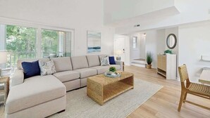 Una sala moderna con sofá, mesa de centro y vistas al exterior.