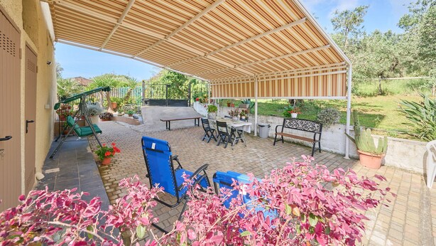 An outdoor patio with a wooden pergola, seating, and potted plants. - Apartment 'La Casa Di Mia' in Piombino (Piombino)