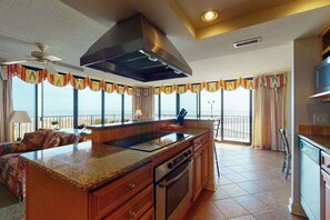 A kitchen with a large island, a stove, and a ceiling fan. - Sea Colony 1st floor condo w/ pool, gym, and balcony - ocean view (Bethany Beach)