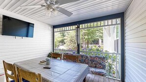 A covered porch with a table, chairs, and a bench. - Savannahs Landing home w/ gas grill & shared pool, tennis, & playground (Ocean View)