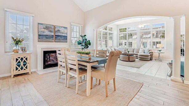 Un salón espacioso con chimenea, mesa de comedor y asientos cómodos.
