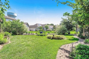 A residential area with a large water tank, a paved pathway, and a well-maintained lawn. - Bayview Landing home with central AC, shared pool, washer/dryer, & free WiFi (Selbyville)