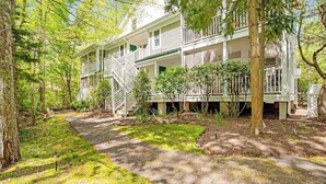 A two-story house with a porch, surrounded by trees. - Terrific Sea Colony Condo w/Private Beach, Free WiFi, Shared Pool & Hot Tub, AC (Bethany Beach)