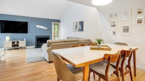 Una sala moderna con comedor, chimenea y obras de arte en las paredes.