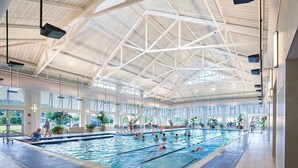 Una piscina interna con alto soffitto e ampie finestre.