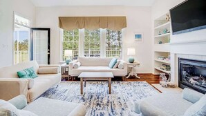 A living room with a sofa, coffee table, and fireplace. - Wonderful Bear Trap Dunes Townhouse w/Free WiFi, Shared Pool, Deck, W/D, & AC (Ocean View)