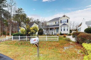 A two-story house with a front porch, a mailbox, and a white fence. - Clearwater Home, perfectly located w/Shared Pool, Private Washer/Dryer, & WiFi (Frankford)