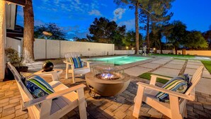 A patio with outdoor furniture, a fire pit, and a swimming pool. - Luxury Villa: Pool, Hot Tub & Fire Pit Near Strip (Las Vegas)