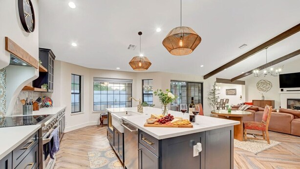 A spacious kitchen with a large island, modern appliances, and a dining area with a fireplace. - Luxury Villa: Pool, Hot Tub & Fire Pit Near Strip (Las Vegas)