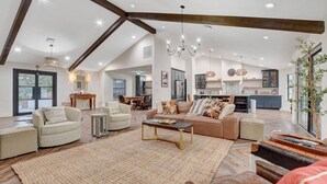 A spacious living area with a high ceiling, a dining area, and a kitchen. - Luxury Villa: Pool, Hot Tub & Fire Pit Near Strip (Las Vegas)