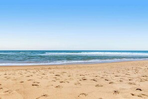 A beach with footprints in the sand and a clear blue sky. - Sea Colony 1st-floor condo - pool, beach access & new appliances (March 2023) (Bethany Beach)