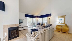 Ein Wohnzimmer mit Kamin, einer Couch, einem Couchtisch und einem Fernseher.