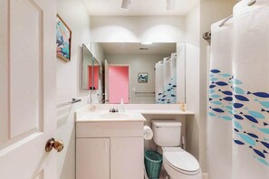 Et badeværelse med toilet, håndvask og spejl.