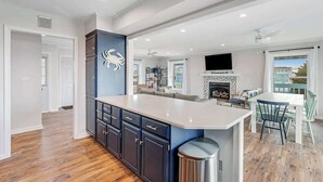 A modern kitchen with a central island, built-in cabinetry, and a fireplace. - Dog-friendly town of Fenwick home with guest suite, WiFi, & elevator (Fenwick Island)