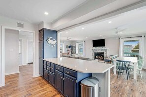 A modern kitchen with a central island, built-in cabinetry, and a fireplace. - Dog-friendly town of Fenwick home with guest suite, WiFi, & elevator (Fenwick Island)