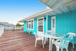 A turquoise building with a wooden deck, a glass table, and white plastic chairs. - Dog-friendly town of Fenwick home with guest suite, WiFi, & elevator (Fenwick Island)