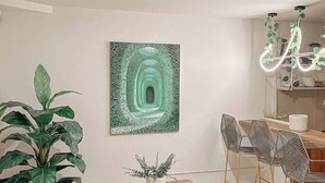 Ein modernes Wohnzimmer mit Couchtisch aus Holz, einem weißen Sofa und einem Essbereich mit Metallstühlen.