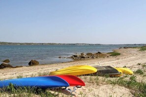 Ein Strand mit Kajaks und ruhiger See.