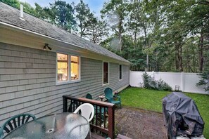 A house with a deck, outdoor seating, and a barbecue grill. - Historic Barnstable Village Home w/ Private Yard - Near Beach (Barnstable)