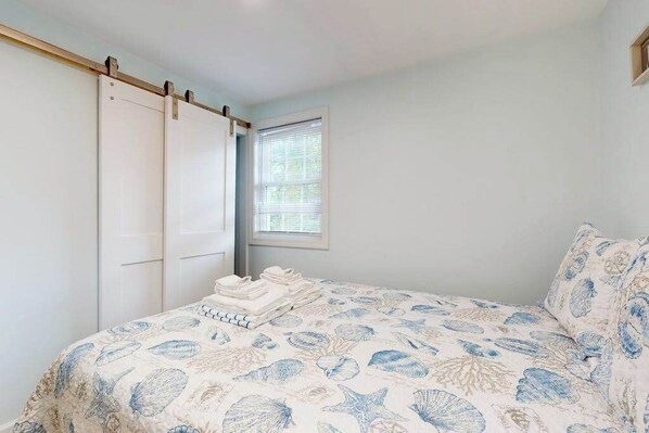 A bedroom with a bed, a window, and a wardrobe. - Dog-friendly duplex with decks, fast WiFi & centralAC - walk to Sea Street Beach (Dennis Port)