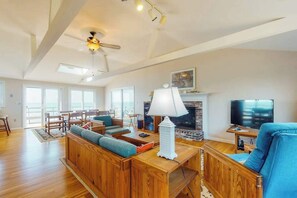 A spacious living room with a fireplace, wooden furniture, and a television.