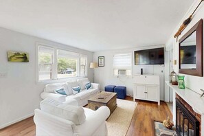 Una sala de estar con un sofá blanco, una mesa de centro y una chimenea.