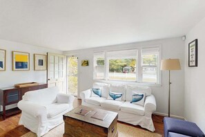 Un salón con un sofá blanco, una mesa de centro y una lámpara de pie.