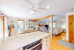 A spacious living area with a kitchen, dining area, and a large window.