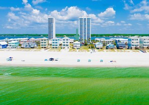 A beachfront hotel with multiple-story buildings, a sandy beach, and a clear view of the ocean. - Gulf Front | 6 Bedrooms | Spacious West Beach Retreat (Gulf Shores)