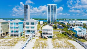 Ein Küstenhotelbereich mit Strandhäusern, einer Promenade und Blick auf das Meer.