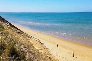 Ein Strand mit sandigem Ufer und freiem Blick auf das Meer.