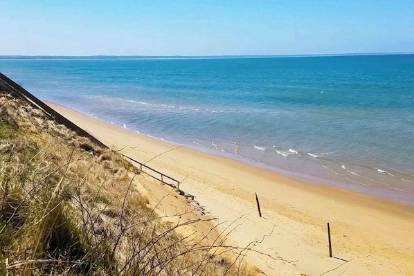A beach with a sandy shore and a clear view of the ocean.
