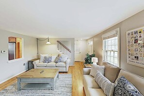Ein Wohnzimmer mit Sofa, Couchtisch und Treppe.