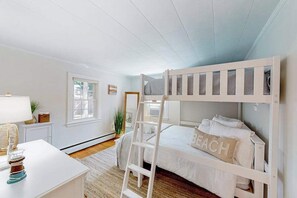 A bunk bed with a ladder, a desk with a lamp, a window, and a plant. - Conveniently-located home with fenced yard, firepit, beach parking pass (Hyannis)