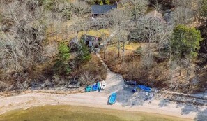 An aerial view of a property with a house, a dirt path, and several boats. - Pond Treasure: Private beach, hot tub, sauna, play area & dog-friendly (Sandwich)