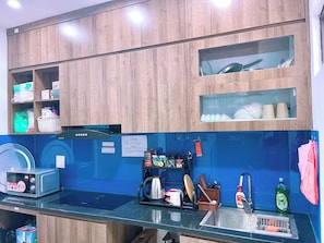 A modern kitchen with wooden cabinets, a built-in microwave, and a stainless steel sink. - A peaceful homestay in the heart of Hanoi, Vietnam (, Bo De Ward, Long Bien District, Hanoi City)