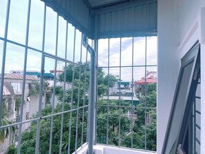 A balcony with metal railings, a view of surrounding buildings, and greenery. - A peaceful homestay in the heart of Hanoi, Vietnam (, Bo De Ward, Long Bien District, Hanoi City)