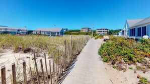 A coastal walkway with buildings, a sandy path, and vegetation. - Cozy waterfront studio w/direct beach access - close to town (Truro)