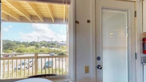 A room with a view of a parking area and a door with a window. - Cozy waterfront studio w/direct beach access - close to town (Truro)