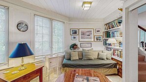 A cozy room with a bed, a desk, a bookshelf, and a clock on the wall. - Beautiful Estate with Large Lawn Made for Socializing and Kids' Playroom (Vineyard Haven)