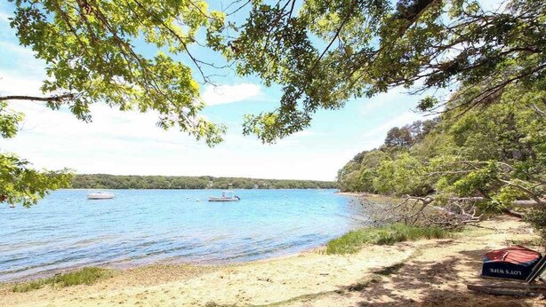 A beach with clear water, boats, and a chair labeled 'Lodge's Lake.' - Beautiful Estate with Large Lawn Made for Socializing and Kids' Playroom (Vineyard Haven)