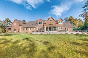 A large brick house with a spacious front yard and multiple windows.