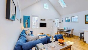 Ein geräumiges Loft mit hohen Decken, einer Essecke und einem Wohnbereich mit Sofa und Couchtisch.