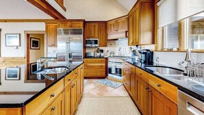 Una cucina con mobili in legno, elettrodomestici in acciaio inossidabile e un'ampia finestra.