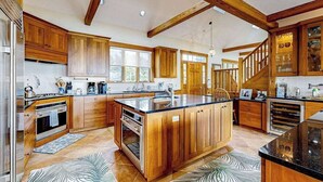 Un'ampia cucina con mobili in legno, un'isola grande e un forno integrato.