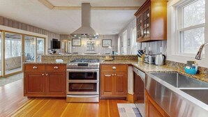Une cuisine spacieuse dotée de meubles en bois, d’appareils électroménagers en acier inoxydable et d’un grand îlot central.
